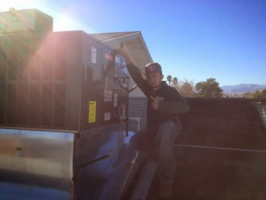 HVAC technician performing HVAC Inspection on a rooftop unit in Raynham